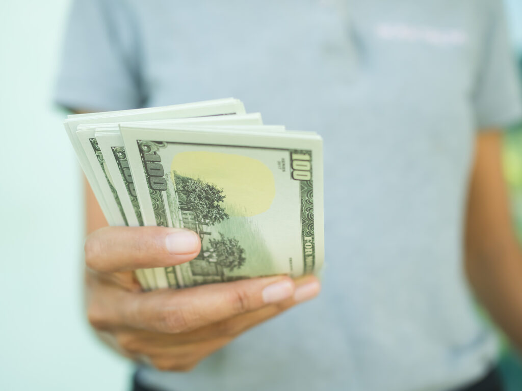 Woman Giving Cash 100 Dollar Closeup.